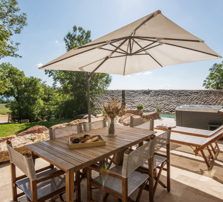 Terrasse avec meuble de jardin et spa privatif, du gîte en Aveyron la Grangette au bord du lac de Pareloup